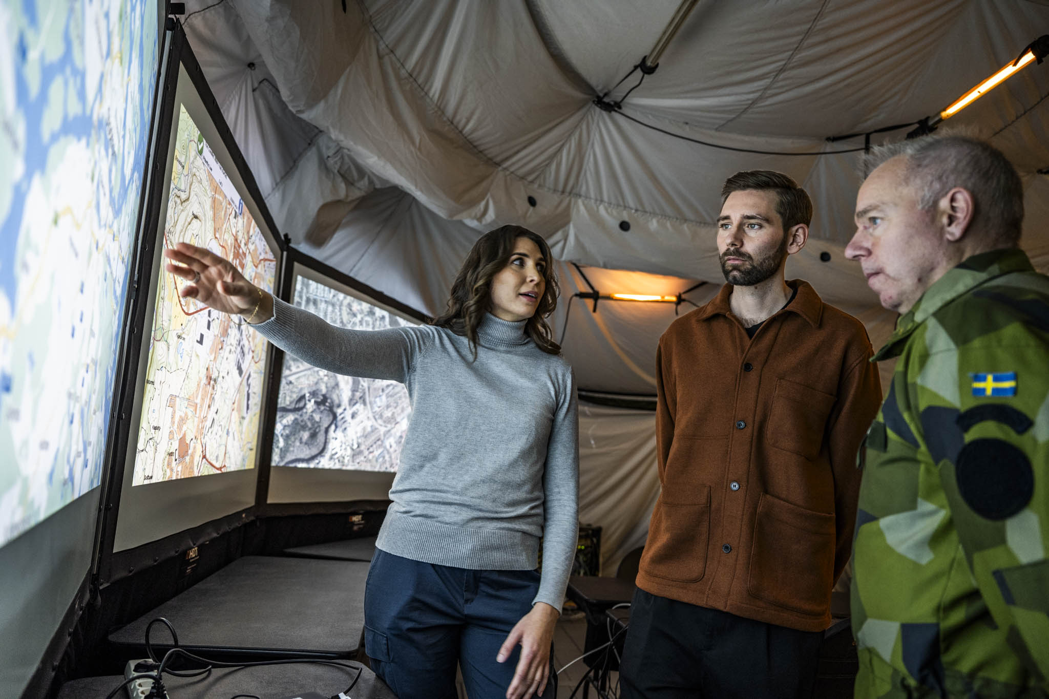 Military and civilian personnel in front of monitor.